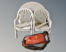 A circular plastic patio table together with four armchairs and Flymo Hover compact 330 lawn mower.