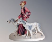 A 20th century crackle glazed figure of a lady walking dogs.