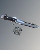 A replica German WWII dagger and replica badge.