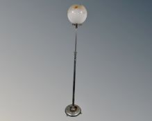 An Art Deco chrome adjustable standard lamp with opaque glass shade.