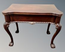 A Georgian style mahogany turnover top tea table on claw and ball feet.