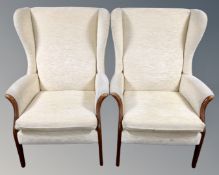 A pair of 20th century beech framed wing back armchairs in cream upholstery