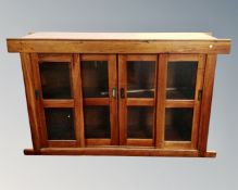 A contemporary hardwood cabinet, with sliding glass doors,