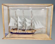 A model of a three masted sailing ship in glazed pine display case, 97cm by 67cm by 33cm.