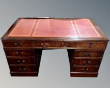 A Victorian style twin pedestal writing desk with tooled red leather inset panel,