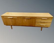 A 20th century teak low sideboard, fitted with cupboards and drawers.