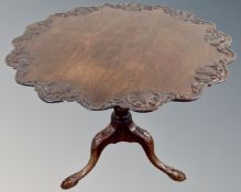 A 19th century mahogany and carved beech tripod table on claw & ball feet,