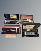 A boxed Starrett micrometer depth gage together with a boxed tachometer and three digital calipers.