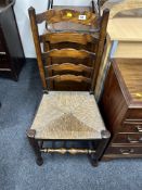 An oak rush seated ladderback kitchen chair.
