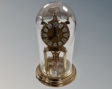 A brass Kundo clock under dome.