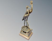 A Japanese brass figure of two herons perched on a tortoise.