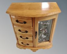 A contemporary musical jewellery box containing assorted costume jewellery.