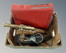 An Xbox 360, a brass model cannon and an AC adapter etc.