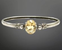 A Scottish silver and citrine bangle, 64mm by 56mm, the oval-cut citrine 12.5mm by 10mm.