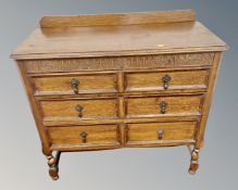 An Edwardian carved oak three drawer chest.