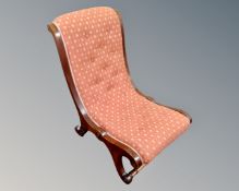 A Victorian nursing chair in buttoned upholstery.