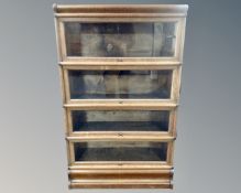 A late Victorian oak glazed door four height stacking bookcase by Globe Wernicke,