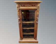 A late Victorian carved oak display cabinet fitted a drawer above,