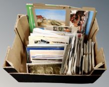 A box of assorted 20th century postcards.