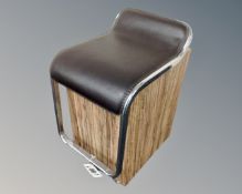 A chrome and teak effect stool on castors.