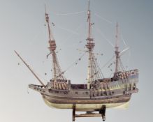 A wooden model of a galleon on stand.