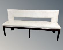 Two bench settees upholstered in cream vinyl.