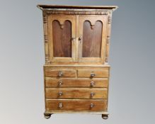 A Victorian mahogany linen press fitted with five drawers beneath on bun feet.