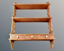 A hanging wall shelf fitted with three drawers.