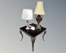 A contemporary black glass topped lamp table on metal legs together with two contemporary table