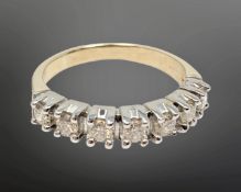 An 18ct white gold seven stone diamond half eternity ring, approximately 0.7ct, size P.