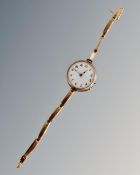 A lady's 9ct gold wristwatch on 9ct gold bracelet, with enamelled dial,
