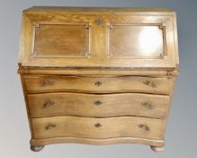 A twentieth century oak serpentine fronted bureau, width 110 cm.