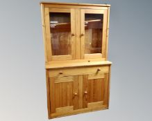 A contemporary pine bookcase fitted with cupboards and a drawer beneath.