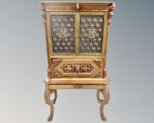 An unusual Dutch heavily carved beech drinks cabinet on stand with fitted interior,