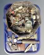 A tin containing assorted trinkets, wristwatches, padlock, vintage razor etc.