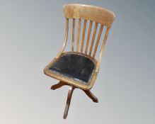An Edwardian oak swivel office chair.