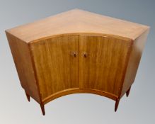 A 20th century teak inverted bow front double door corner cabinet.