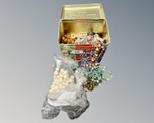 A tin of costume jewellery,