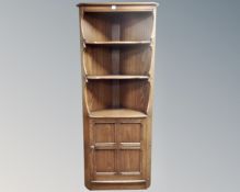 An Ercol stained elm corner cabinet.