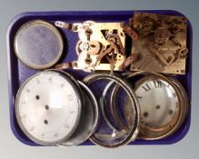 A tray containing assorted clock dials and movements.