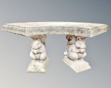 A concrete garden bench on squirrel pedestals