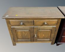 A heavy oak double door cabinet fitted with two drawers