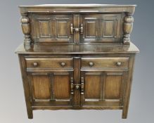 An Ercol elm and beech buffet backed sideboard in antique finish