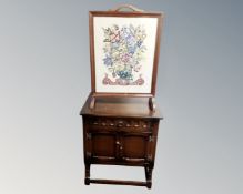 An oak double door cabinet fitted a drawer on raised legs together with a fire screen