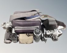 A box containing vintage cameras including Canon AE-1, Praktica MTL3 together with assorted lenses,