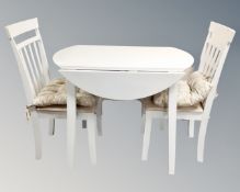 A contemporary white drop leaf kitchen table with two chairs.