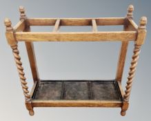 An oak barley twist stick stand with metal tray.