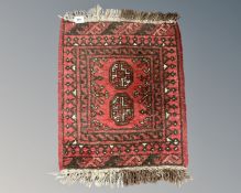 A small Afghan Bokhara fringed rug, 74cm by 53cm.