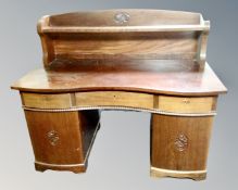 A continental serpentine front mahogany twin pedestal desk.