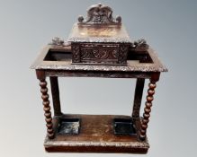 A Victorian heavily carved oak umbrella stand with central lidded box.